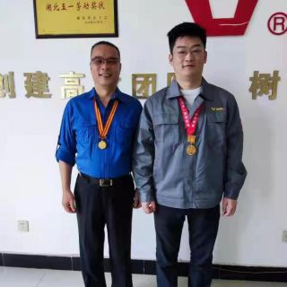  陶宏國（左）和陶力（右）父子倆佩戴五一勞動獎章合影  